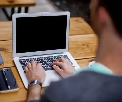Człowiek piszący na MacBooku